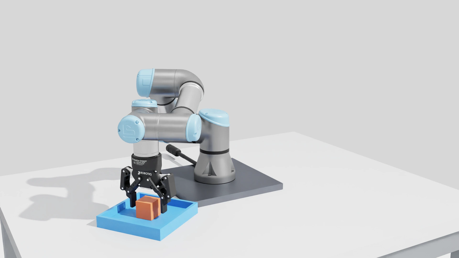 UR3e pick-and-place: Opening the gripper lets the cube settle into the tray.